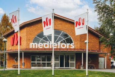 En tegelbyggnad med flaggor framför.