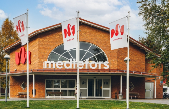 En tegelbyggnad med flaggor framför.