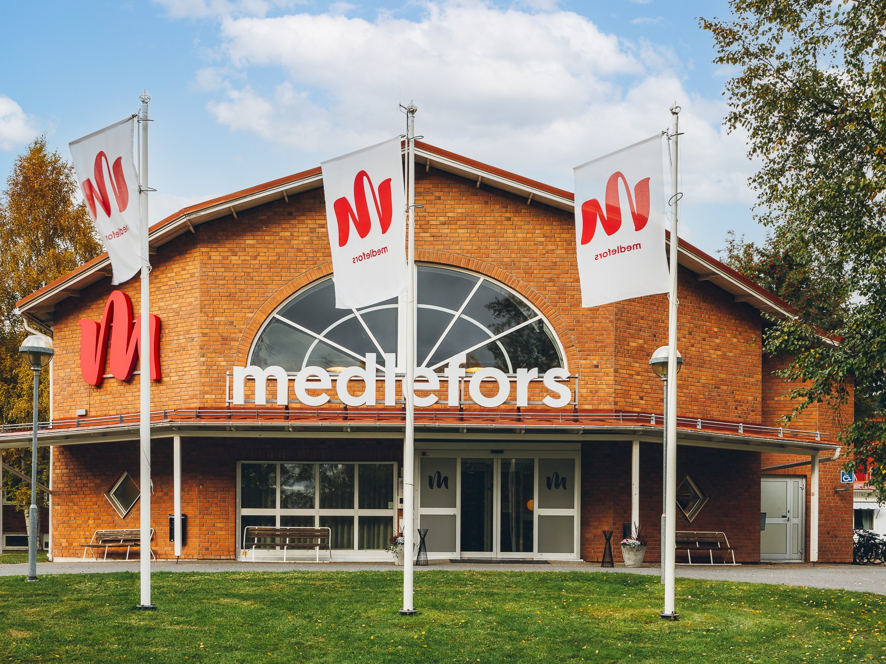 En tegelbyggnad med flaggor framför.