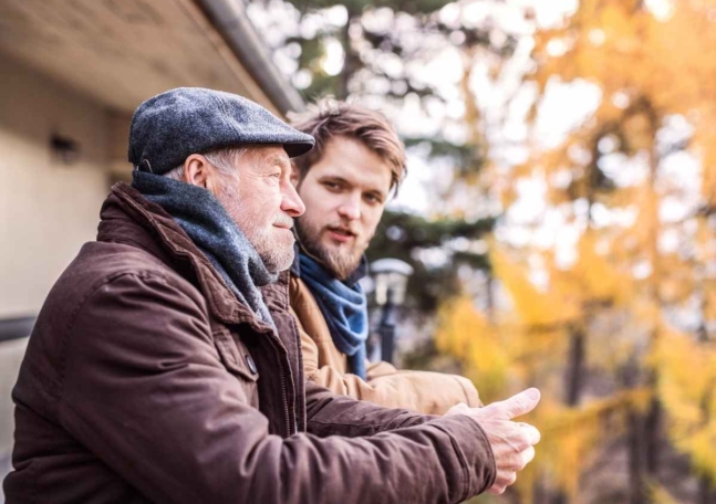 En äldre man och en yngre man samtalar.