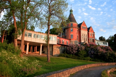 En röd tegelbyggnad med en gräsmatta runtom.