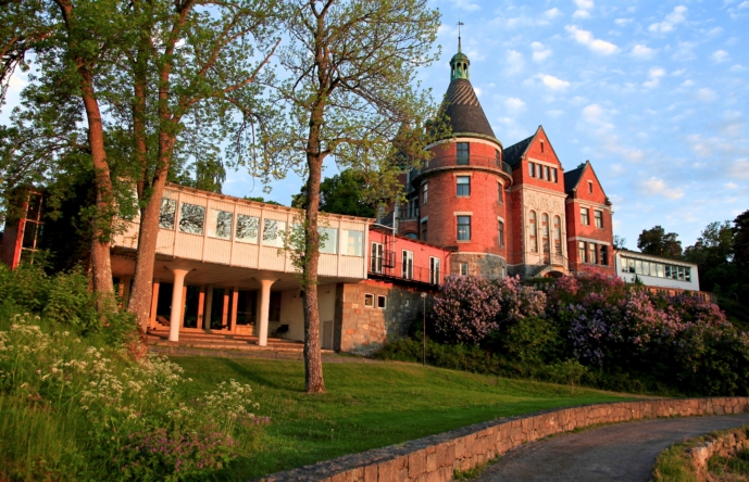 En röd tegelbyggnad med en gräsmatta runtom.