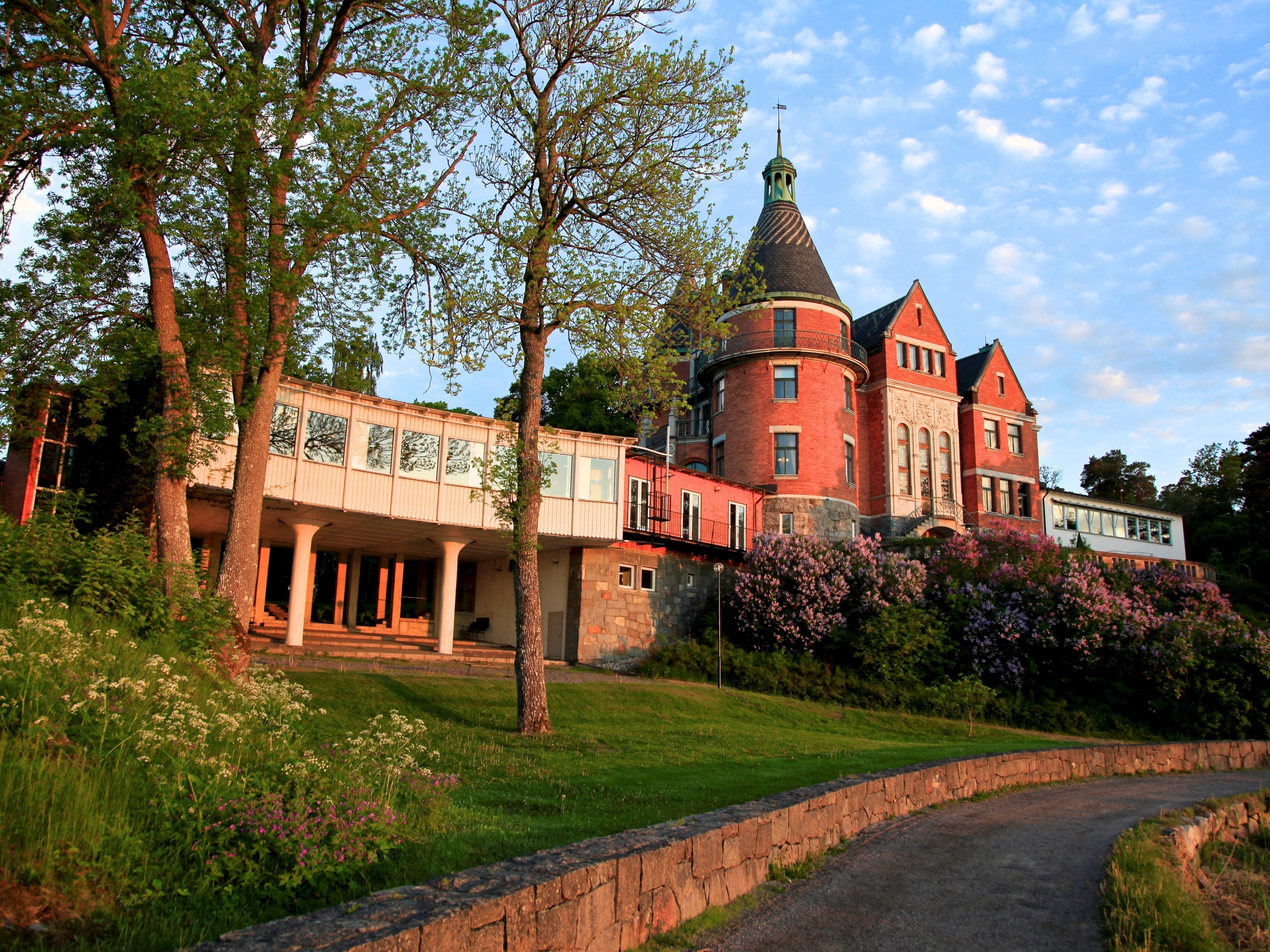 En röd tegelbyggnad med en gräsmatta runtom.