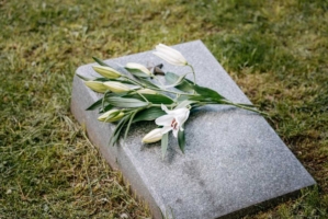 En bukett med vita blommor ligger på en gravsten.