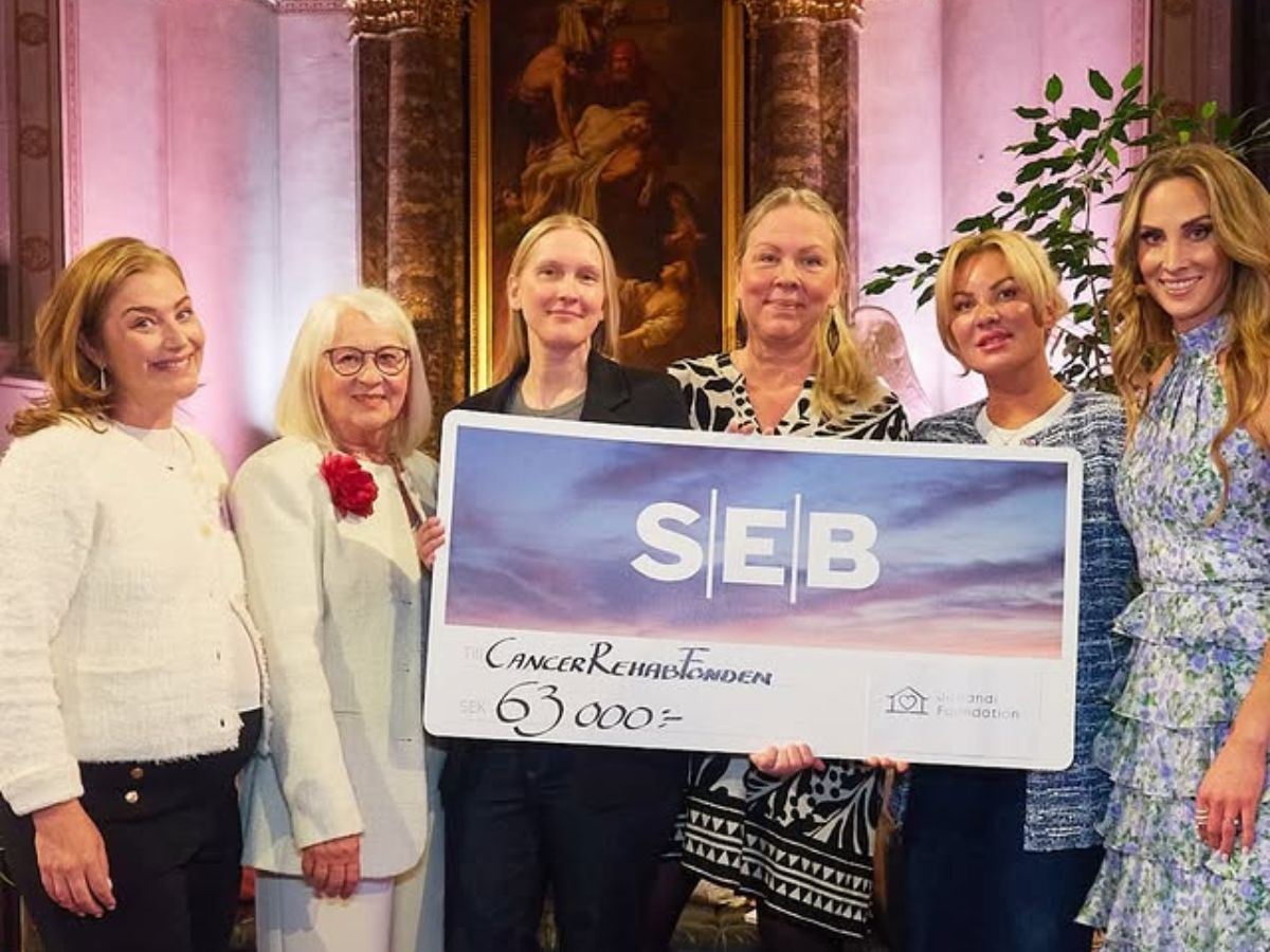 En grupp kvinnor står på rad och håller upp en SEB-check.