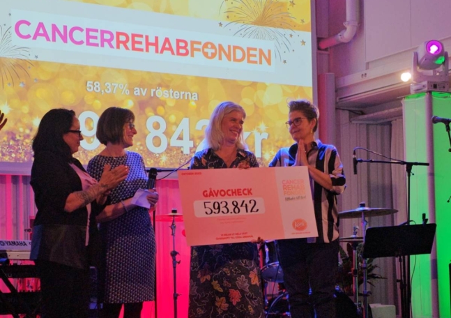 CancerRehabFondens generalsekreterare Pia Watkinson tar emot en gåvocheck från Kavli.