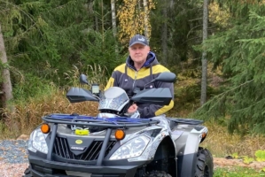Marko, som intervjuas i artikeln, sitter på en fyrhjuling med skogen som bakgrund.