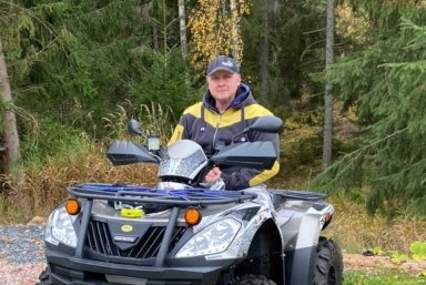 Marko, som intervjuas i artikeln, sitter på en fyrhjuling med skogen som bakgrund.