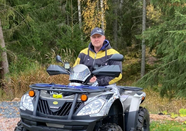 Marko, som intervjuas i artikeln, sitter på en fyrhjuling med skogen som bakgrund.