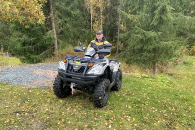 En man utomhus sittandes på sin fyrhjuling.