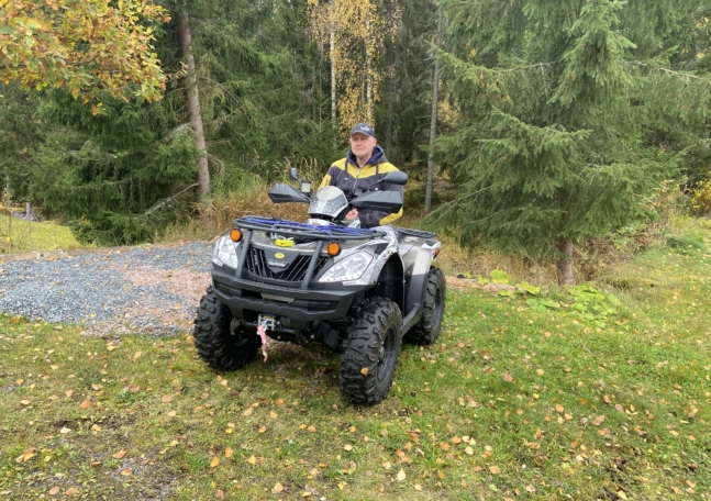 En man utomhus sittandes på sin fyrhjuling.