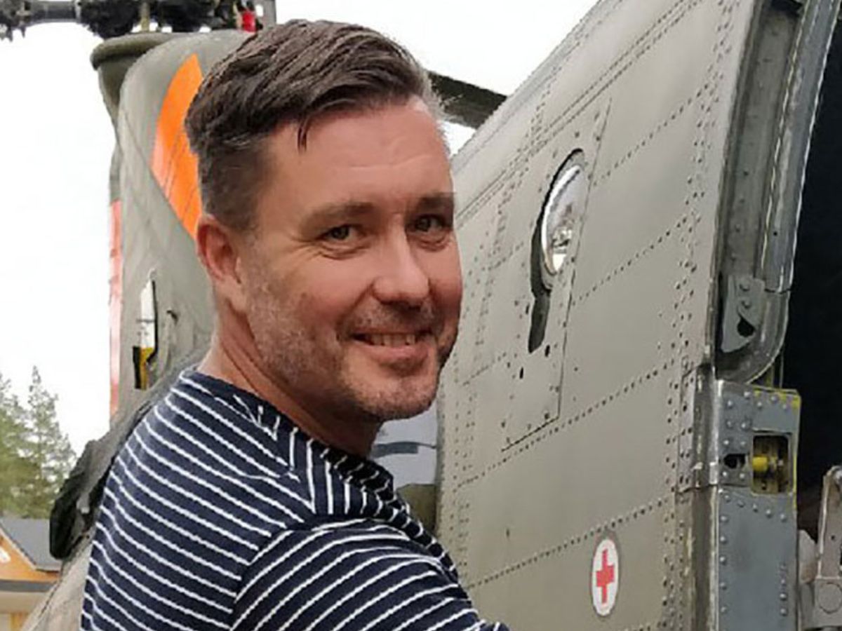 En man i randig tröja ler och tittar in i kameran.