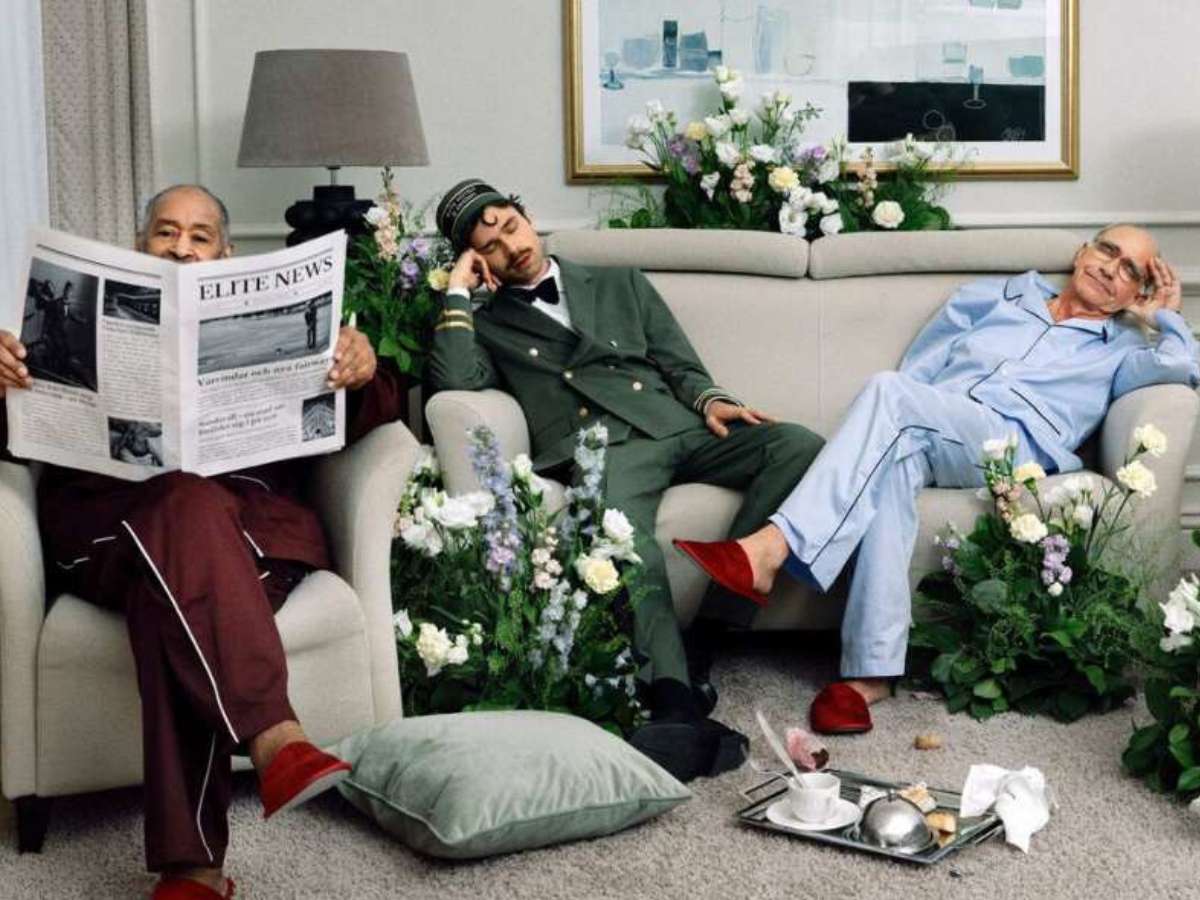 Tre personer sitter i en soffa och fåtölj i ett fint hotellrum.
